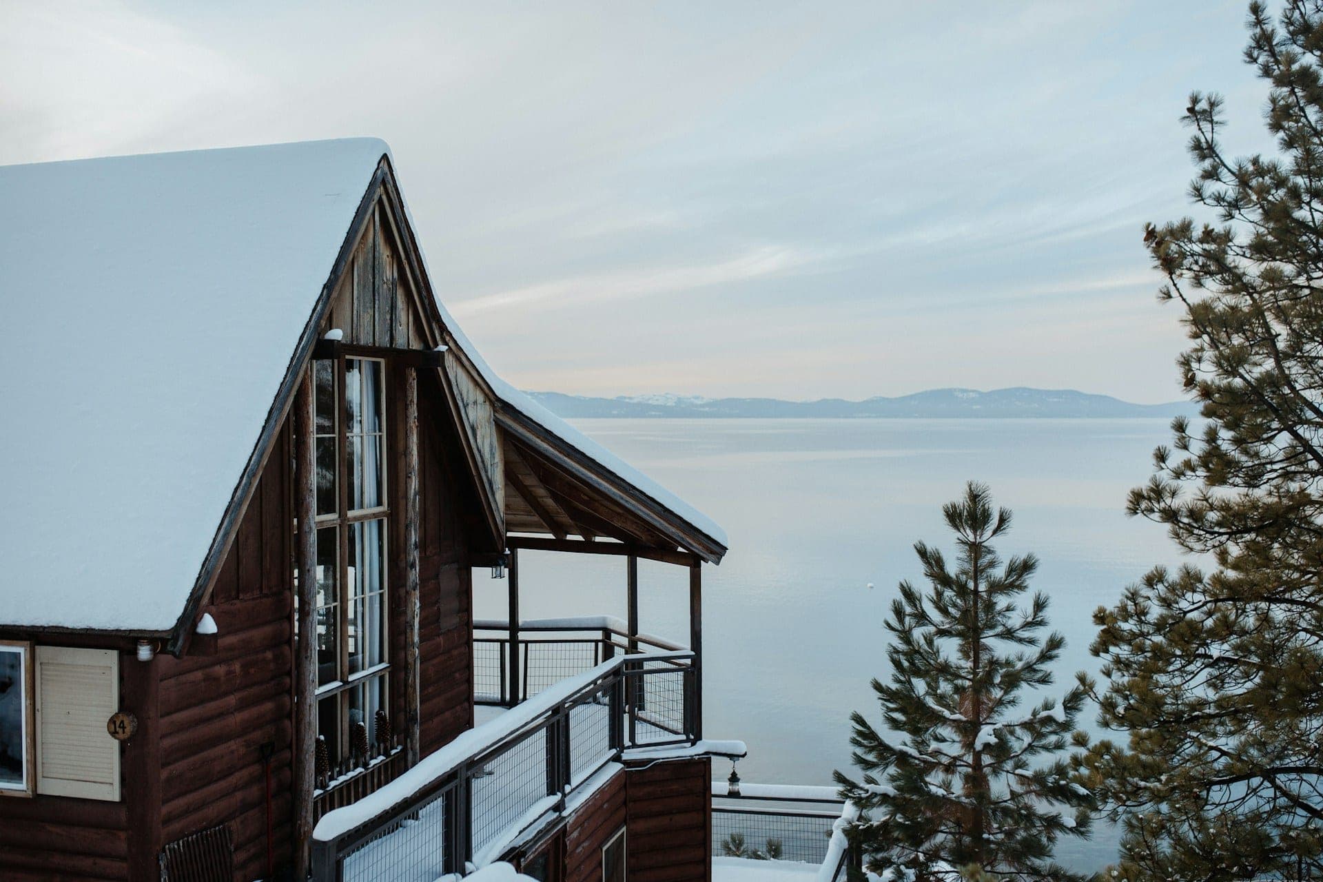 A-frame cabin among pines above Lake Tahoe on a winter afternoon